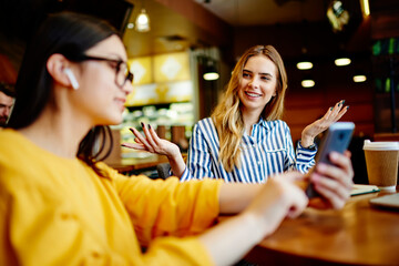 Young women talking about last news surfing smartphone