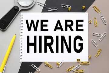 we are hiring . notepad on a background of different colors. brown, black, gray