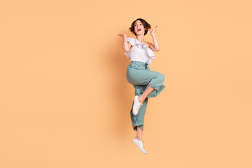 Fototapeta na wymiar Photo of excited pretty young lady wear off-shoulder blouse smiling jumping looking empty space isolated beige color background