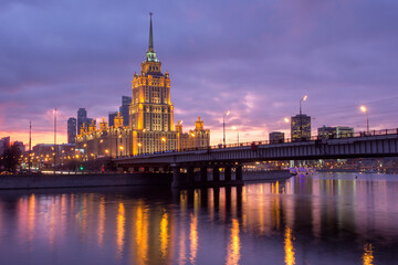 Naklejka premium Sunset on the river. Moscow Stalin-era skyscraper at sunset. Evening illumination.