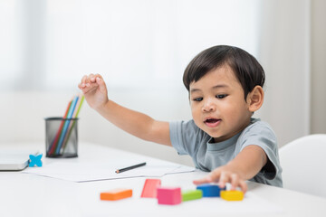 Asian little boy education from home. Developing children's learning before entering kindergarten Practice the skills of playing with wooden toys in living room.