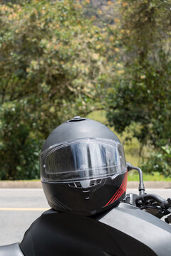 casco negro encima de una moto con fondo natural 