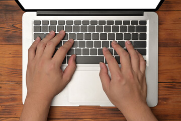 Top view of hands using a white blank screen computer laptop on the wooden desk.