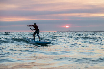 Man with paddle board in water to surfing