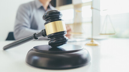 Judge gavel with Justice lawyers having team meeting at law firm background. Concepts of Law and...