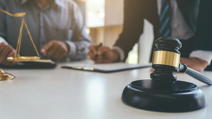 Judge gavel with Justice lawyers having team meeting at law firm background. Concepts of Law and...