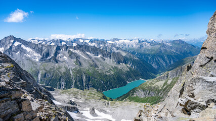 Summer alpine scenery with turquoise blue water reservoir. Zillertal Alps, Austria