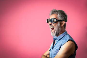 portrait of a crazy hipster man shouting loud with arms crossed, melting glasses and fashion...