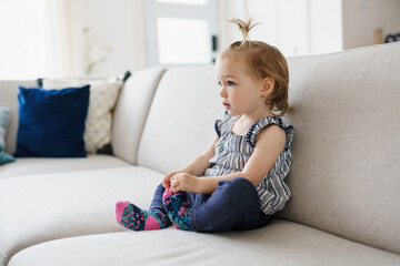 cute little girl watching tv at home