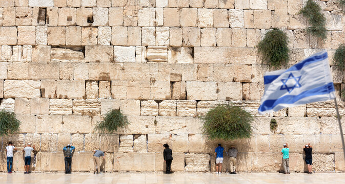Jerusalem, Israel - September 7, 2021 -Jewish orthodox believers reading the Torah and praying facing the Western Wall, also known as Wailing Wall in the old city in Jerusalem, Israel. 