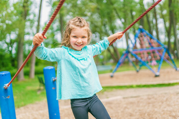 Happy little girl is playground having fun