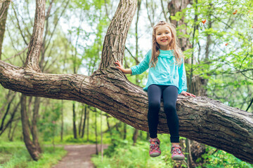 little girl on tree in the summer on nature little girl