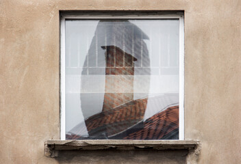 Reflections of chimney in the window glass on the exterior wall