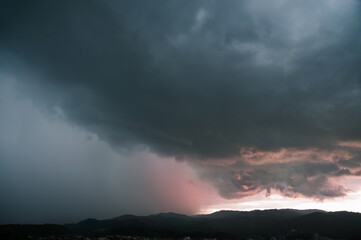 夕日を浴びて赤く染まる雨雲
