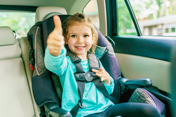 Small child sitting in a car doing thumb up - Powered by Adobe