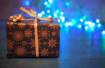 Christmas gift box on a blue surface with a blurred background