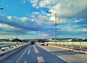 구름 낀 파란 하늘 아래 도로