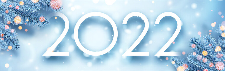 2022 Christmas blue spruce branches with bokeh lights.