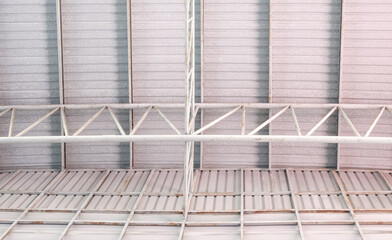 The metal frame of the roof structure with the roof tile covers the large warehouse.