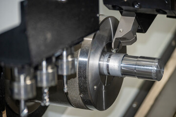 Fototapeta na wymiar The CNC lathe machine slot cutting the metal shaft parts.