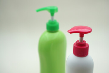 Plain white and green soap bottles on a white background                               