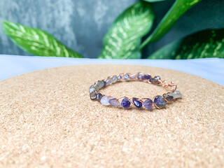 wire bracelet with amethyst stone and shell on the background.