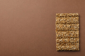 Delicious kozinaki bar on brown background, top view. Space for text