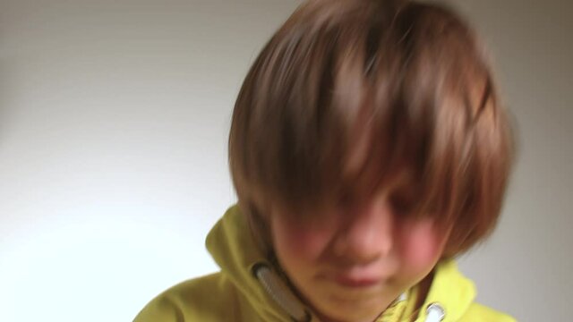 An inspired teenager makes dance moves, shakes her hair at the camera. Motivation for a playful mood. Yellow clothes.