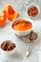 Creamy and delicious soup from roasted pumpkin with chili flakes pepper and rye crispy toast. Vegetarian autumn comfort food concept