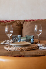 Mesa de restaurante turístico en la playa con copas, vasos, platos y cubertería completa