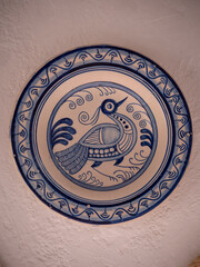 Vertical view of Old retro ceramic decorative plate with a bird motive.