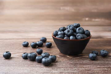 Set of blueberries in a bowl on a wooden table