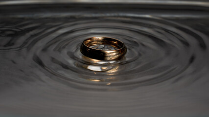 Gold ring with a pattern in a dark dialect - obrazy, fototapety, plakaty