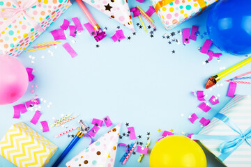 Birthday party attributes. Colorful balls, confetti, gifts, candles for cake. Blue background. Top...