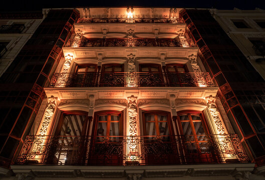 Edificio de lujo y decorado con molduras ornamentales bellamente iluminado de noche en Toledo.
