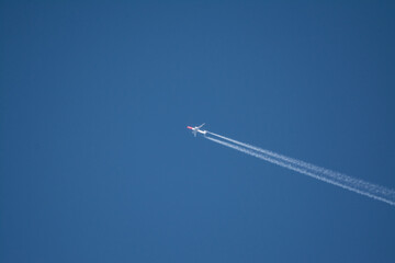 Plane in blue sky with vapour trail