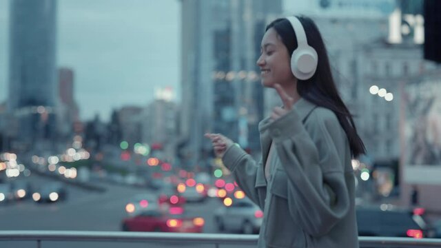 Attractive woman listening songs in modern headphones