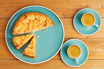 Homemade pie with nectarines and two cups of coffee espresso on wooden table. Top view.