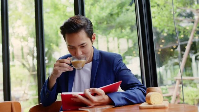 Asian businessman drinking hot coffee in Co-working space to take break from work. Happy relaxing in a coffee shop. Concept inspiration 