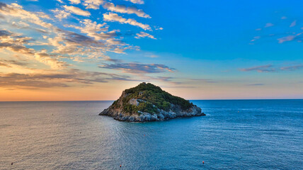 the island of bergeggi at dawn. in the middle of the sea on a beautiful summer day