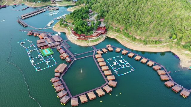 Wooden raft resort floating on dam with mountain