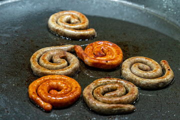 assorted pork sausages and beef rolled into a circle grilled