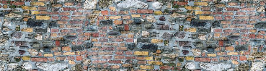 Texture brick narrow background stone base. Colorful wall of the house