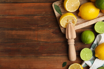 Squeezer with lemons on wooden table, flat lay. Space for text