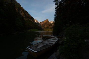 Epic sunrise by an alpine lake in Switzerland called Seealpsee. The sun shines to the peak of the mountain on the other side of the lake. This looks so wonderful.
