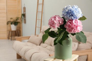 Beautiful hortensia flowers in can on stand indoors. Space for text