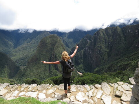 Backpacker woman feeling the freedom in a spectacular mountains landscape near Machu Picchu in Peru