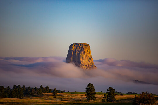 Devils tower surrounded by clouds
