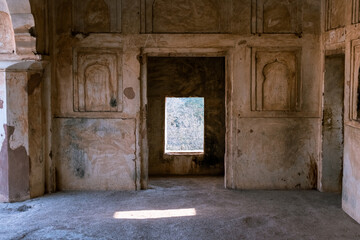 Geometric rectangular windows and niches on the rustic walls of the ancient Raja Mahal palace in Orchha.