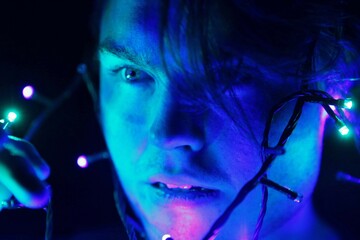 Man in close up with string lights